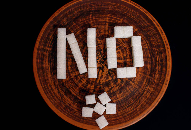 κύβους ζάχαρης, σε ένα ξύλινο, καφέ πιάτο, όχι, ζάχαρη επιγραφή - Φωτογραφία, εικόνα