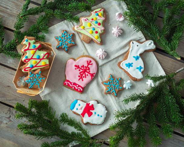 Délicieux régal de biscuits glacés au pain d'épice et de biscuits meringues colorés, décorés de branches d'épinette
 - Photo, image