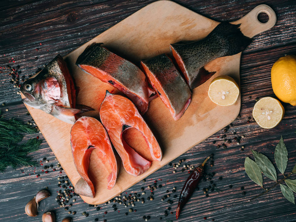sliced trout on a Board on a wooden table with lemon and seasonings. Fresh red fish - Photo, image