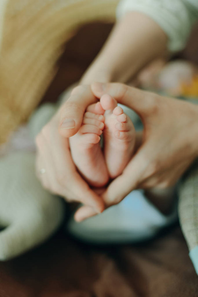 Baby voeten in moeder handen. Mam en haar kind. Gelukkig familieconcept. Mooi conceptueel beeld van moederschap - Foto, afbeelding