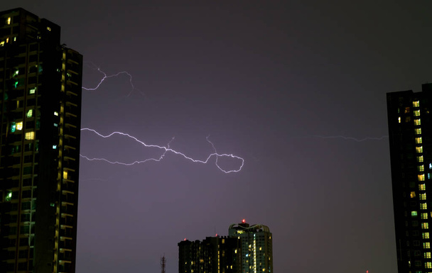 der echte Blitz am Nachthimmel über den hohen Gebäuden - Foto, Bild