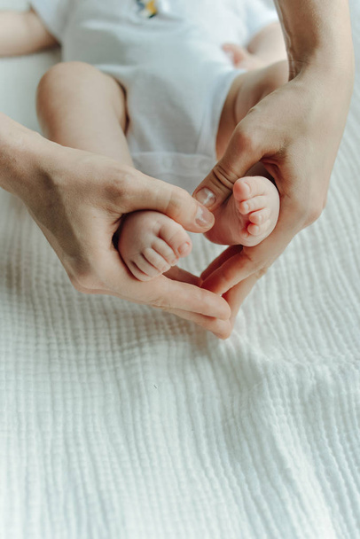 Ноги новорожденного ребенка и руки матери сердце
 - Фото, изображение