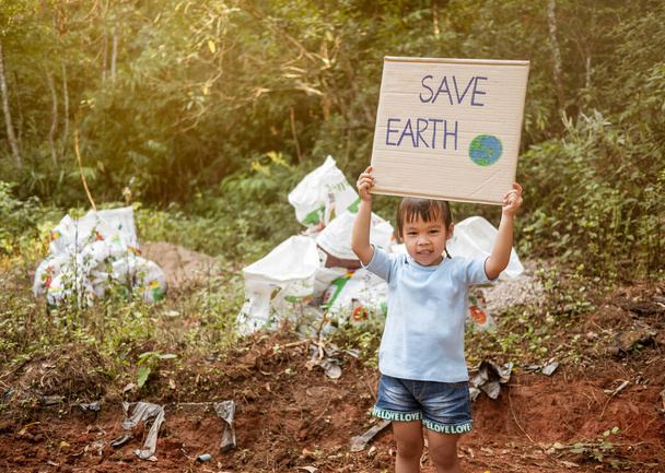 Το μικρό κορίτσι κρατώντας "Save The Earth" Αφίσα που δείχνει ένα  - Φωτογραφία, εικόνα