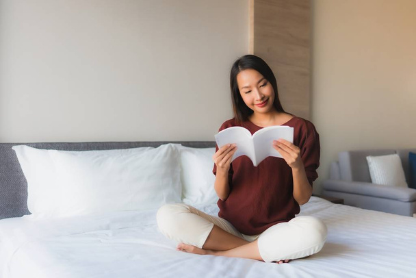 Muotokuva kaunis nuori aasialainen naiset lukeminen kirja sängyssä
 - Valokuva, kuva