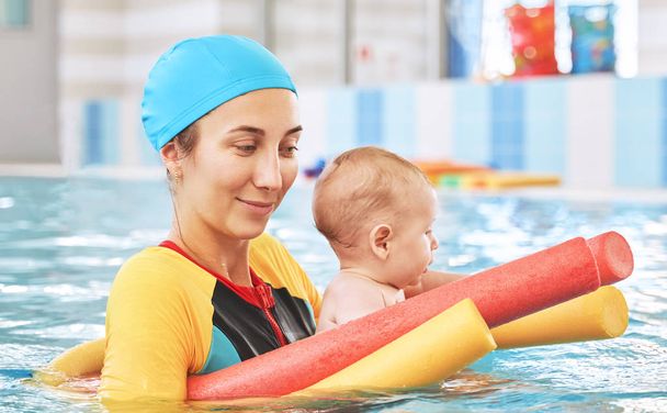 Młoda matka i mały syn są w basenie uczy pływać - Zdjęcie, obraz