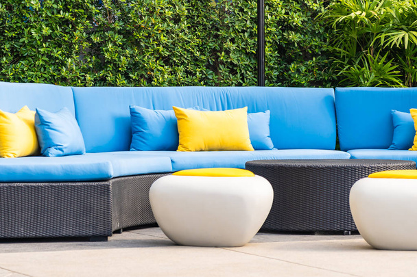 Odkryty patio w ogrodzie z sofą krzesło i poduszki dekoracji - Zdjęcie, obraz