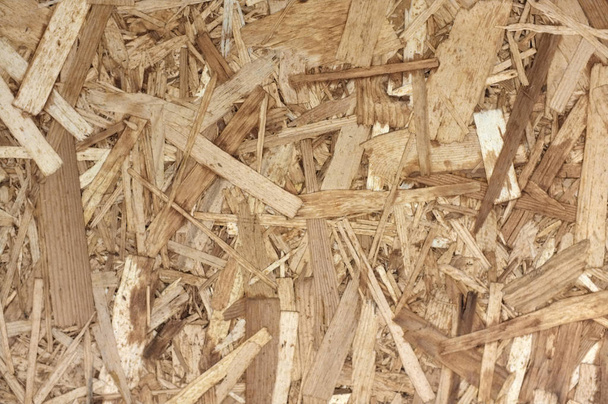 OSB Boards or brown wood chips sanded into a wooden background.  - 写真・画像