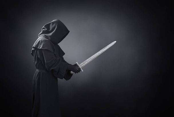 Ghostly figure with medieval sword in the dark - Фото, зображення