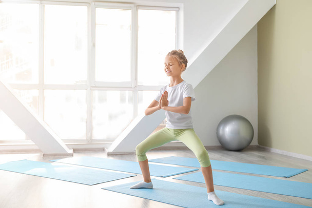 Little girl practicing yoga in gym - Фото, изображение