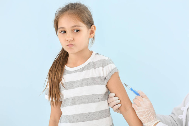 Lekarz szczepienie małej dziewczynki na lekkim tle - Zdjęcie, obraz