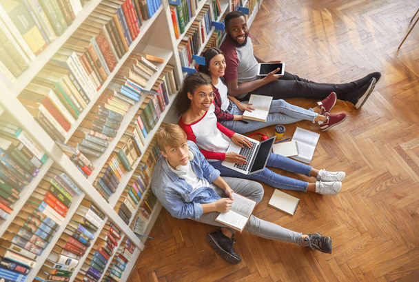 Fiatal diákok készülnek vizsgára a könyvtárban - Fotó, kép