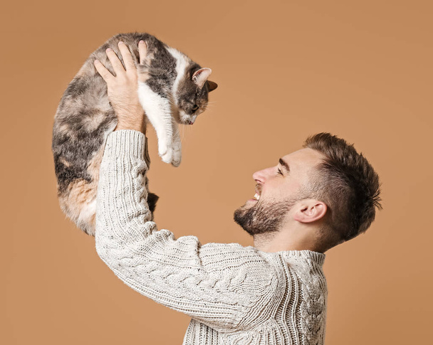 Man with cute cat on color background - Foto, immagini