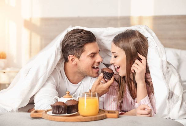 Genç çiftin yatakta kahvaltı ettiği bir sabah. - Fotoğraf, Görsel