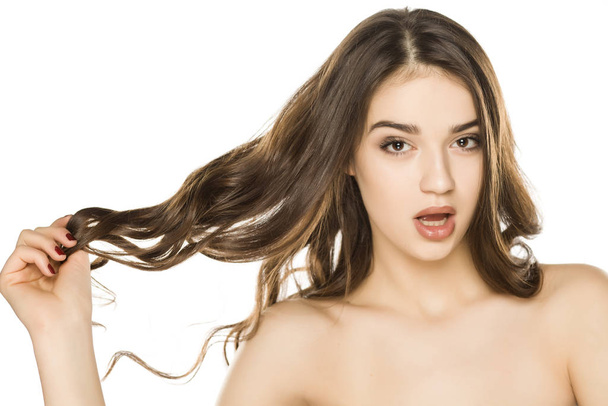 Молода жінка з макіяжем оголошення довге волосся, позує на білому тлі
 - Фото, зображення