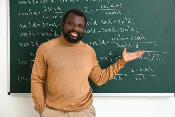 Africko-americký učitel matematiky v blízkosti tabule ve třídě - Fotografie, Obrázek