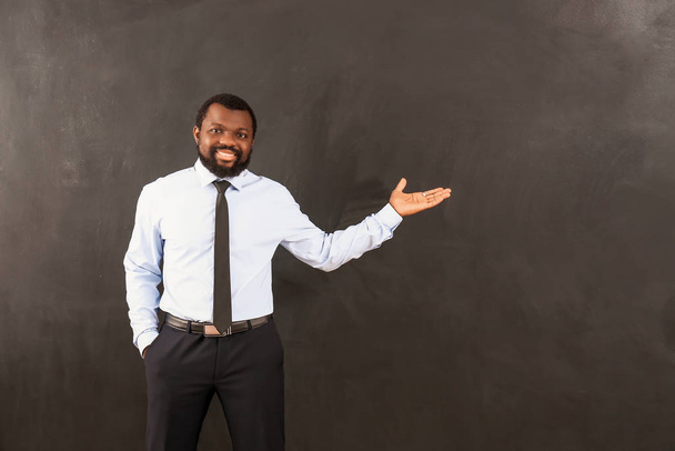 Professor afro-americano perto de quadro negro em sala de aula
 - Foto, Imagem
