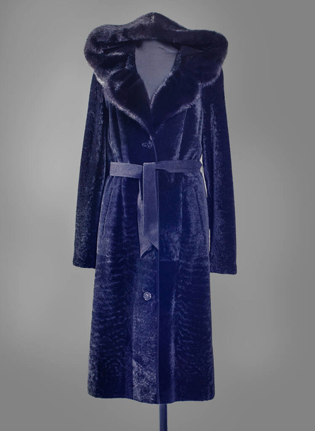 Темно-синий мутонский меховой плащ с вьющимся капюшоном, отделанный норковым мехом, силуэт с поясом
 - Фото, изображение