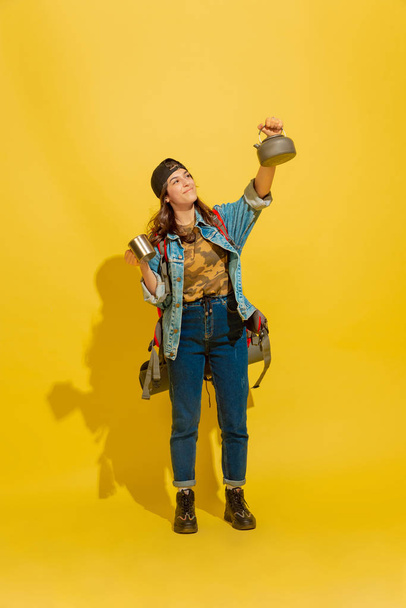 Portrait of a cheerful young caucasian tourist girl isolated on yellow background - Foto, immagini