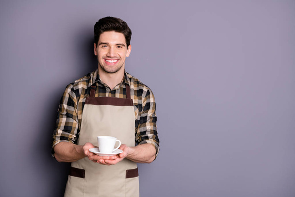 Photo of trendy cheerful fun positive barista serving you cup of tea giving stretching hands to deliver isolated grey color background - Foto, afbeelding