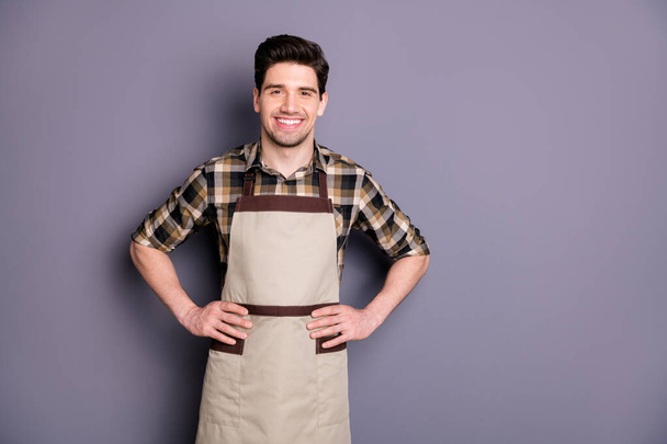 Photo of handsome brunet guy arms by sides friendly smiling inviting visitors on aroma coffee professional worker wear apron plaid shirt isolated grey color background - Fotó, kép