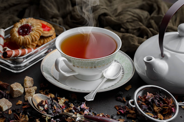 Ζεστό τσάι σε ένα φλιτζάνι σε ένα παλιό φόντο. - Φωτογραφία, εικόνα