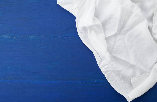 toalha têxtil de cozinha branca dobrada em uma mesa de madeira azul de o
 - Foto, Imagem