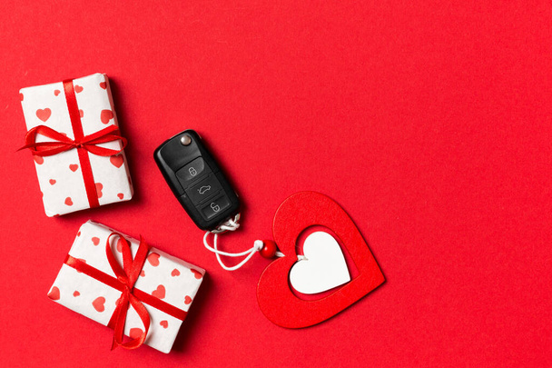 Top view of car key, gift boxes and toy heart on colorful background. Saint Valentine's Day concept with copy space - Photo, Image