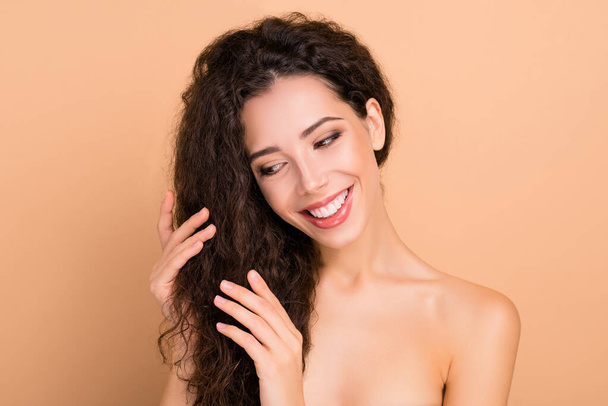 Close-up portrait of her she nice-looking groomed attractive lovely gorgeous winsome perfect cheerful wavy-haired girl touching curls shower gel isolated over beige pastel background - Fotografie, Obrázek