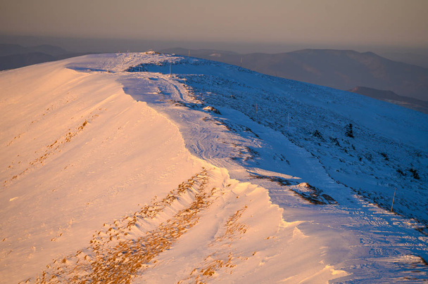 Snow on the mountains ridge in warm sunrise light - 写真・画像