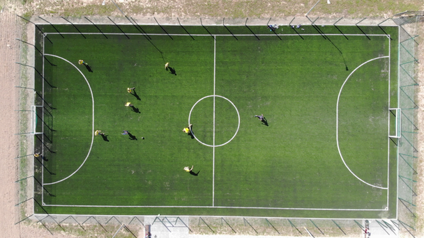 Aerial view of a soccer game being played at nighttime with floodlights lighting the field. - Footage, Video