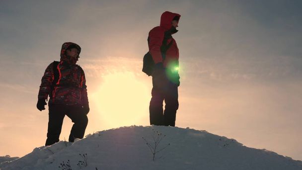 Karlı bir dağdaki gezginler arazi tarafından yönlendirilir ve hareket yönünü seçerler. Alaska 'lı gezginler karlı bir tepenin zirvesine çıkar. İnsanların takım çalışması. iş takım çalışması, zafer ve başarı. - Fotoğraf, Görsel