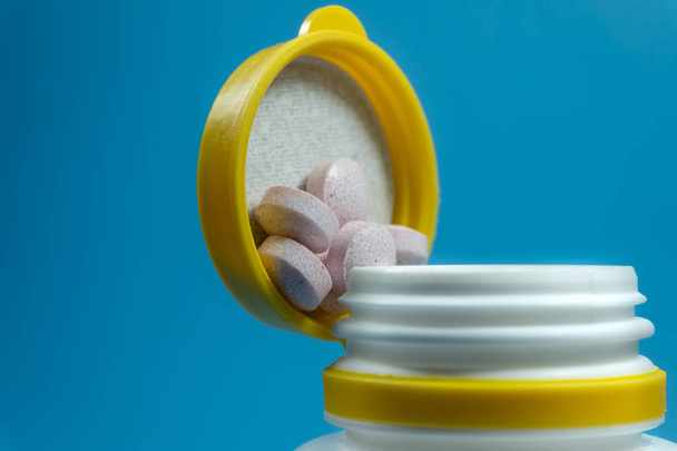 Pillole medicinali fuoriuscite da una bottiglia bianca
 - Foto, immagini