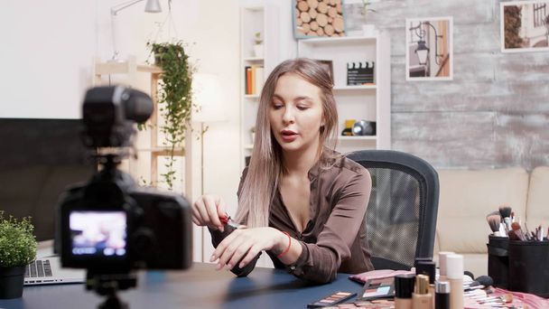 Beroemde schoonheid vlogger het oppakken van een borstel voor make-up - Foto, afbeelding
