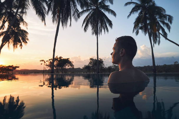 Zwembad te midden van kokospalmen - Foto, afbeelding