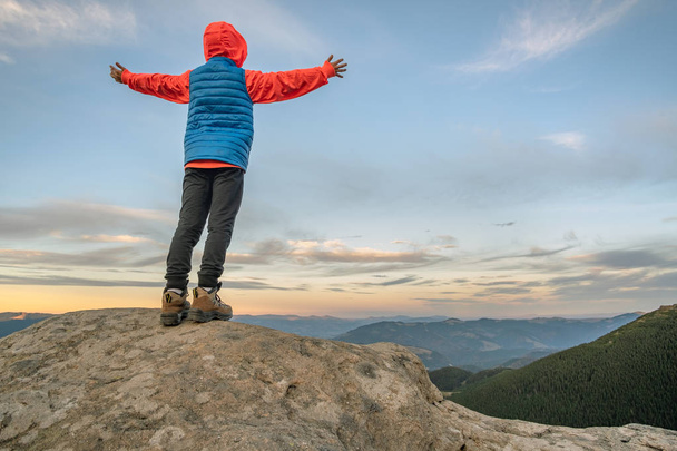 Fiatal gyermek fiú túrázó álló emelt kézzel a hegyekben hu - Fotó, kép