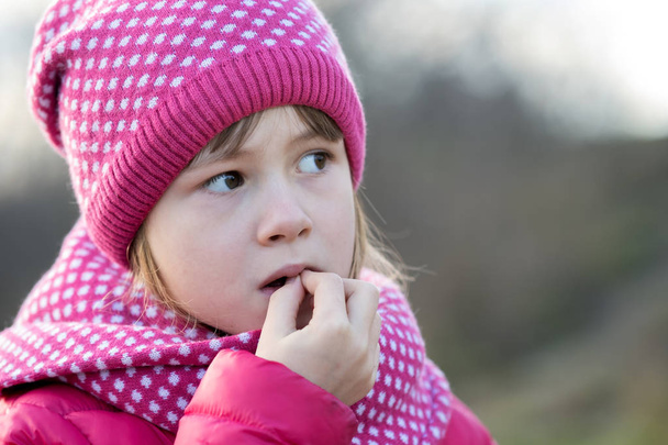Pretty child girl in warm knitted winter clothes outdoors. - Photo, Image