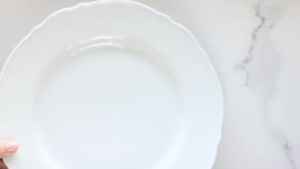Lege witte porseleinen borden op marmeren tafel, tafelkleed diner decor plat lay, top view food videografie als recept inspiratie voor koken vlog of flatlay menu - Video