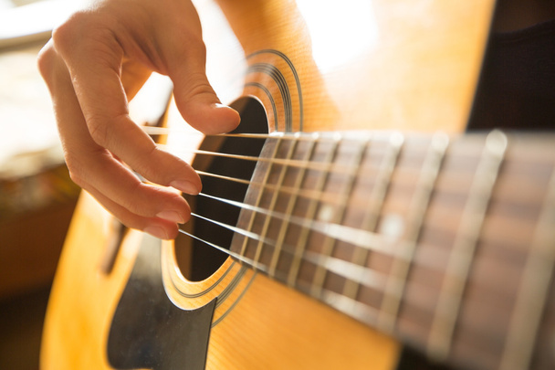 Női kéz akusztikus gitáron játszik. Közelkép. - Fotó, kép