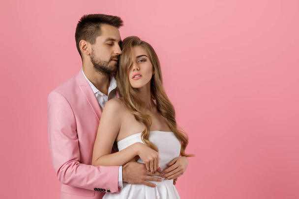 happy couple in love embracing on pink background. st valentines day - Фото, изображение