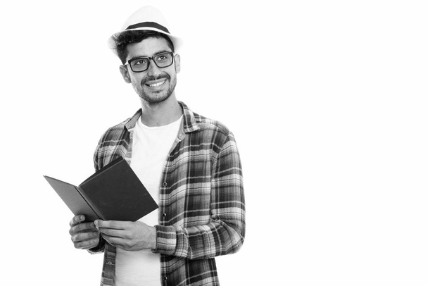 Estudio toma de joven feliz persa hombre sonriendo mientras sostiene libro y pensando
 - Foto, Imagen