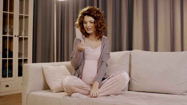 felice donna incinta mostrando ultrasuoni fetali in posa loto sul divano
 - Filmati, video