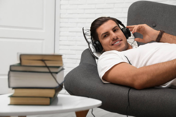 Man with headphones connected to book - Фото, изображение