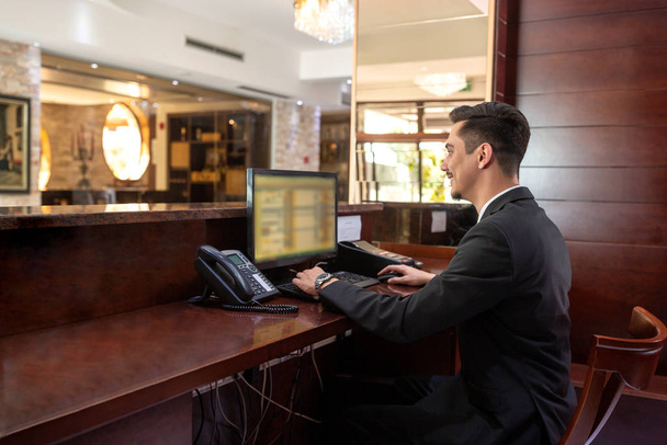 Front desk hotel receptionist working  - Фото, изображение