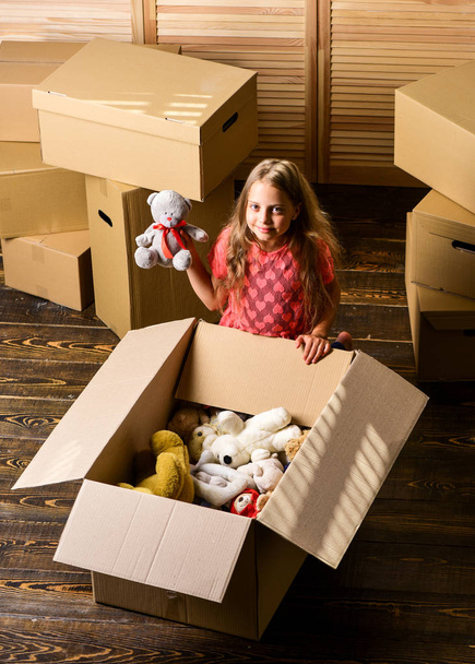 Box package and storage. Small child prepare toys for relocation. Kid girl relocating boxes background. Relocating concept. Delivery service. Happy childhood. Relocating family stressful for kids - Photo, image