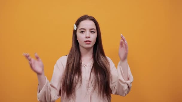 Disappointed woman in fashion pastel shirtspreads hands, unhappy - Footage, Video