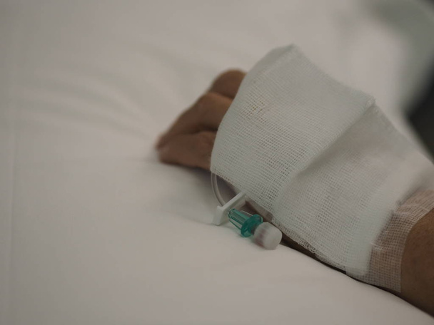 Пацієнти сплять на ліжку встановили IV сольовий розчин у жіночій руці в лікарні
 - Фото, зображення