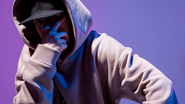 Modern Epic portrait of bboy in a neon light hoodie. Beneath the hood. Dark face. Mysterious and cool. - Fotoğraf, Görsel