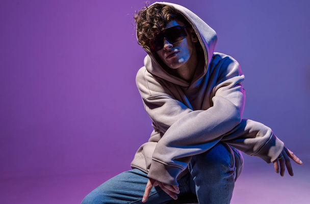 Modern Epic portrait of bboy in a neon light hoodie. Beneath the hood. Dark face. Mysterious and cool. - Foto, afbeelding
