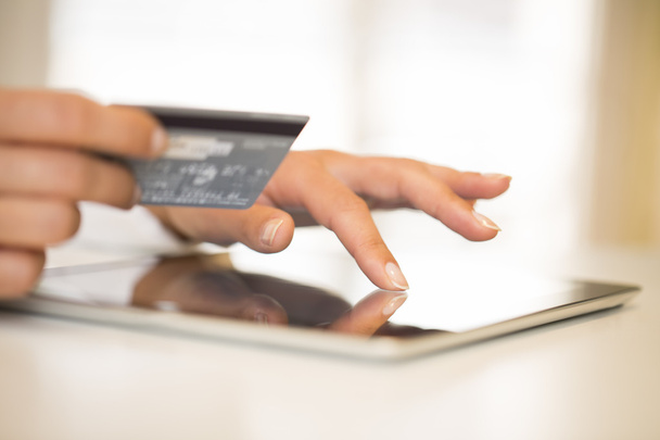 Close-up woman's hands holding a credit card and using tablet pc - Foto, Imagen