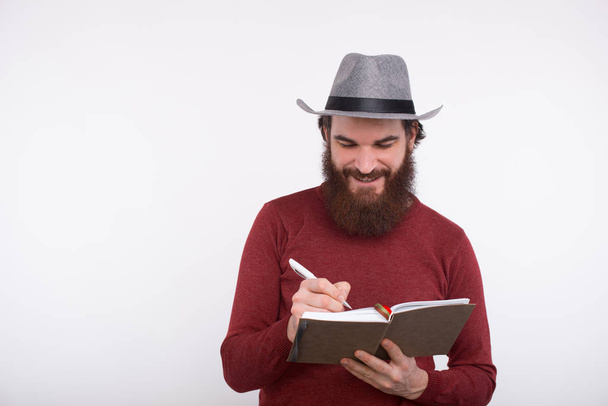 Happy bearded man wrinting in his new planner, time management - Fotoğraf, Görsel